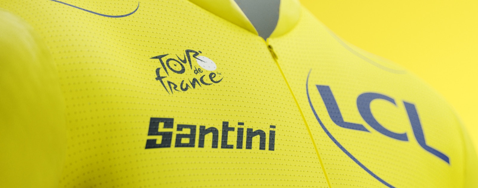 Close-up of a yellow Tour de France jersey featuring the logos of Tour de France, LCL, and Santini.