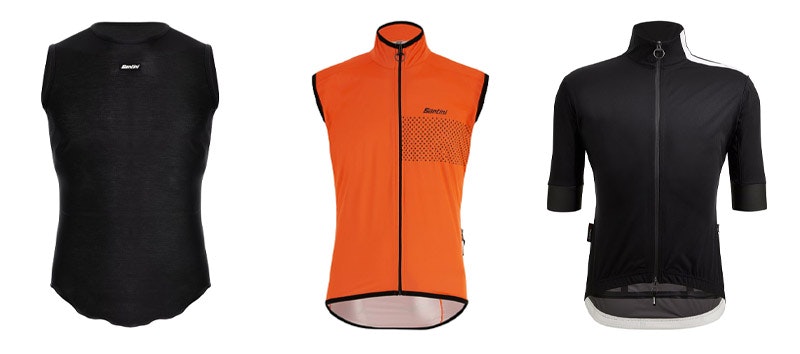 Three cycling jerseys black sleeveless baselayer, orange sleeveless jacket, and black short-sleeve jacket.