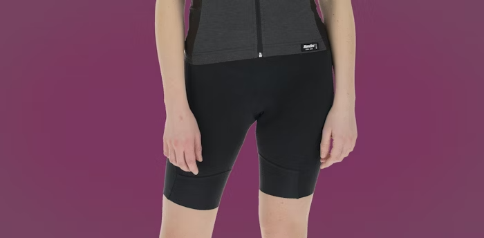 Woman Wearing Black Cycling Shorts with Black Jersey on a Maroon Background